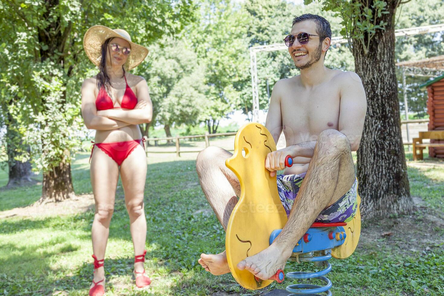 Young adult plays on a spring toy duck photo