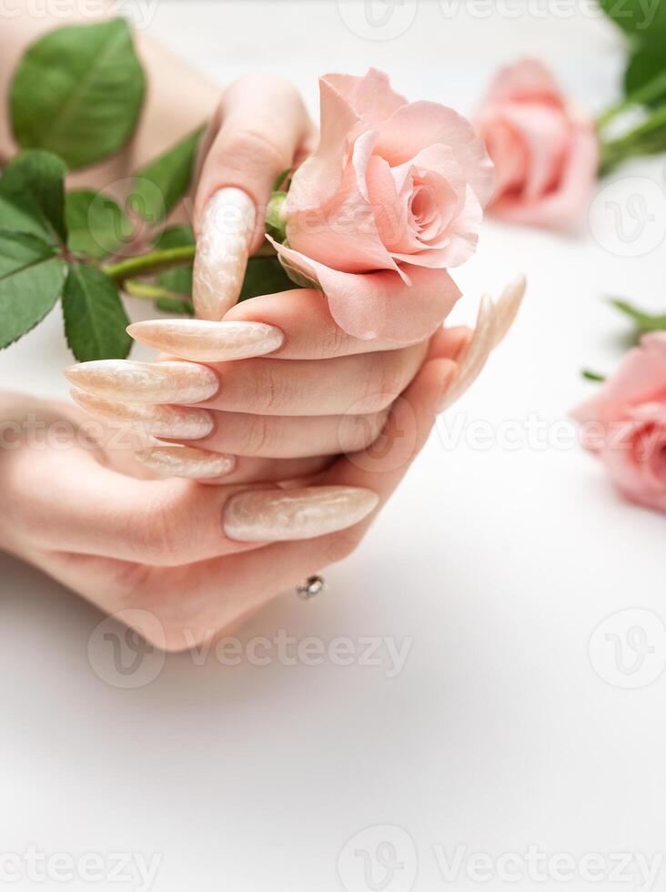 hembra manos en un blanco antecedentes con hermosa perla manicura foto