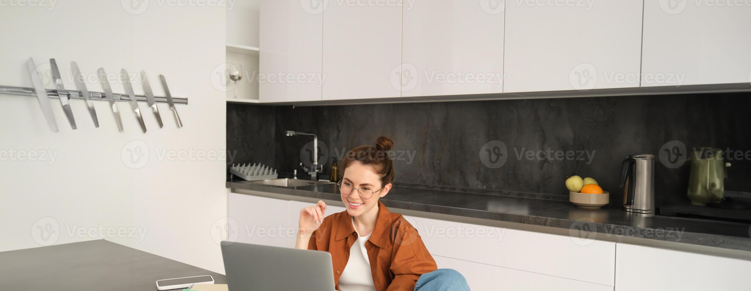 Portrait of young freelancer, woman tutor working from home, giving online lessons. Student connects to remote class from computer and looking at screen photo