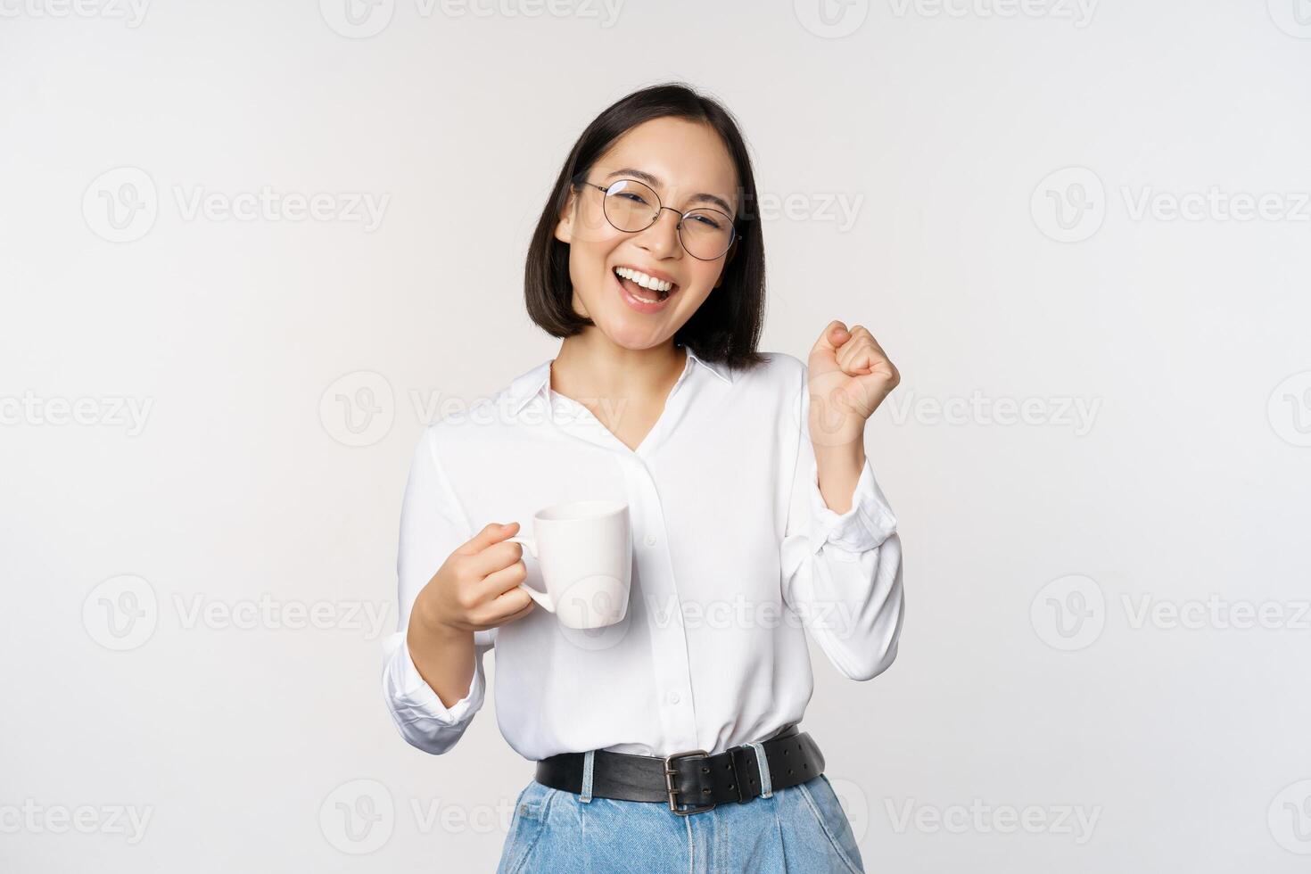 contento bailando mujer Bebiendo café o té desde taza. coreano niña con taza, en pie terminado blanco antecedentes foto