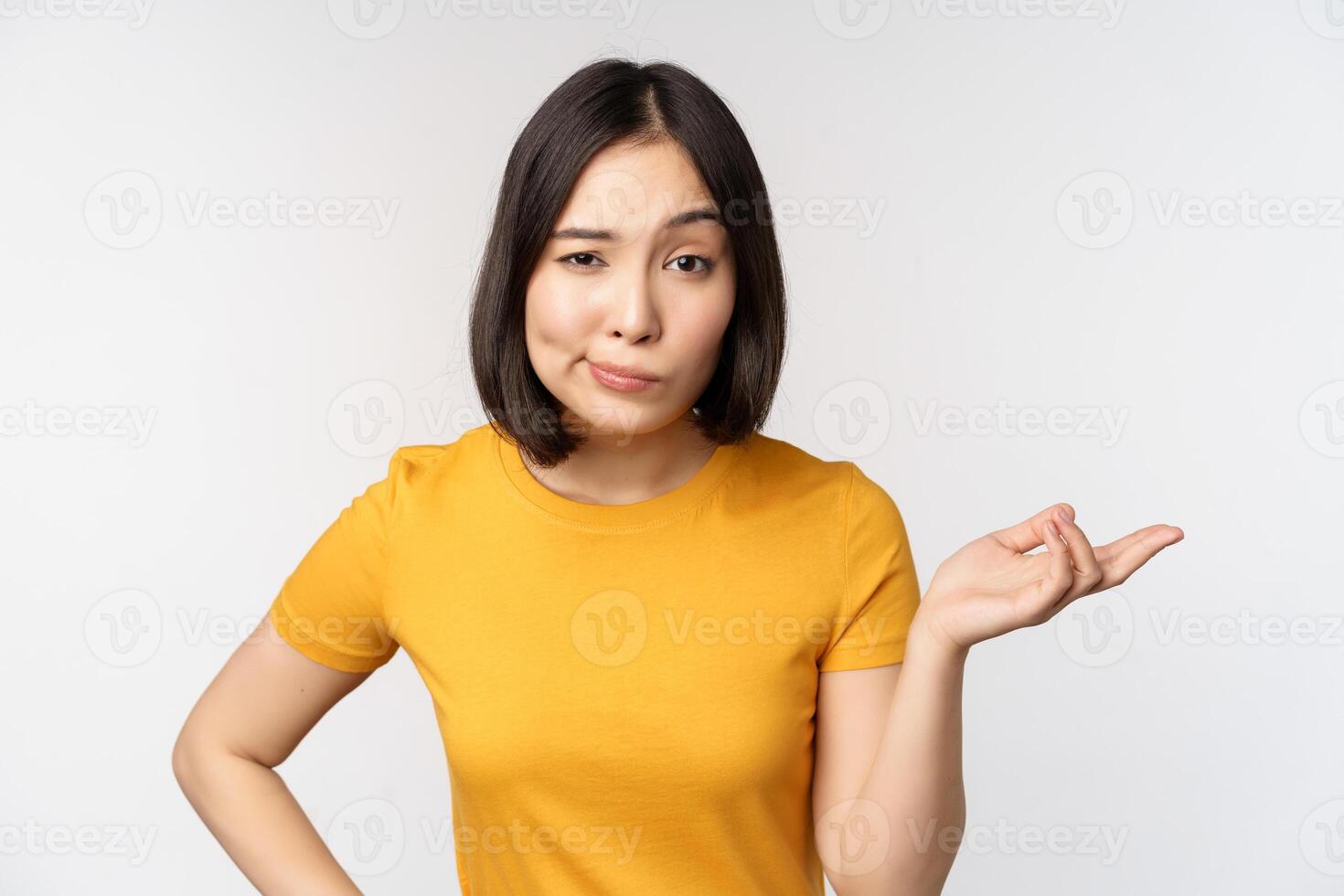 So what. Unbothered asian woman shrugging, looking clueless, standing against white background photo