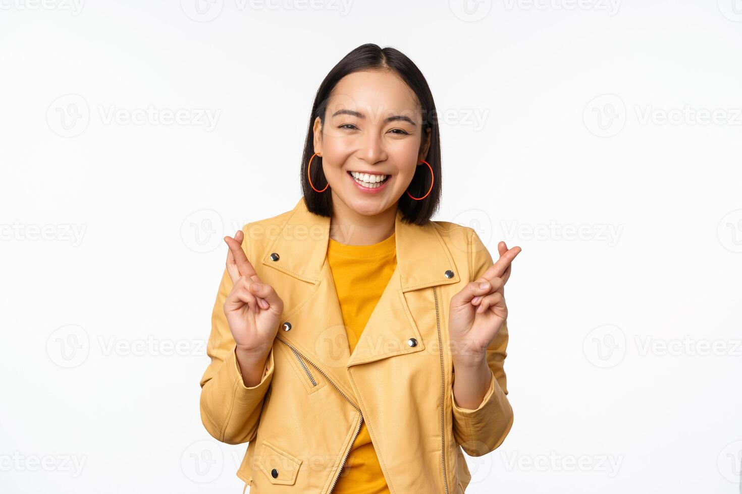 retrato de emocionado asiático mujer mira esperanzado, deseando, Orando o mendicidad, esperando para noticias, en pie terminado blanco fondo, sonriente entusiasta foto
