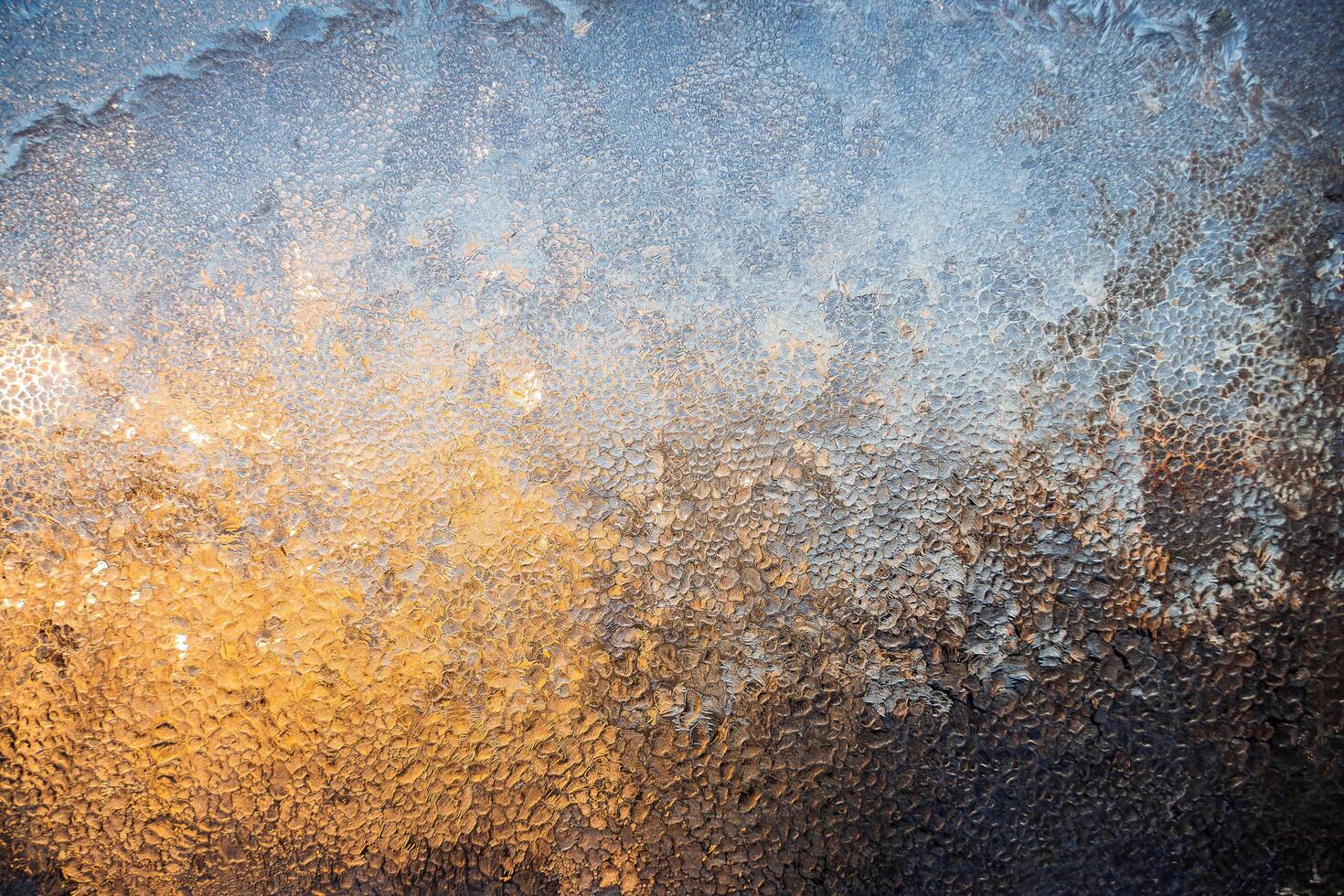 Magical winter patterns on the glass.The texture of the glass covered with frost in winter in cold. Natural phenomena. Frozen water on the window. photo