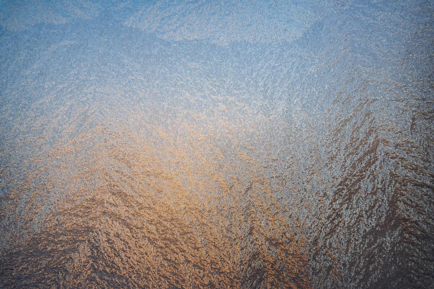 Magical frost and ice patterns on a winter glass. Natural phenomena. Winter decorations, frozen water on the window. photo