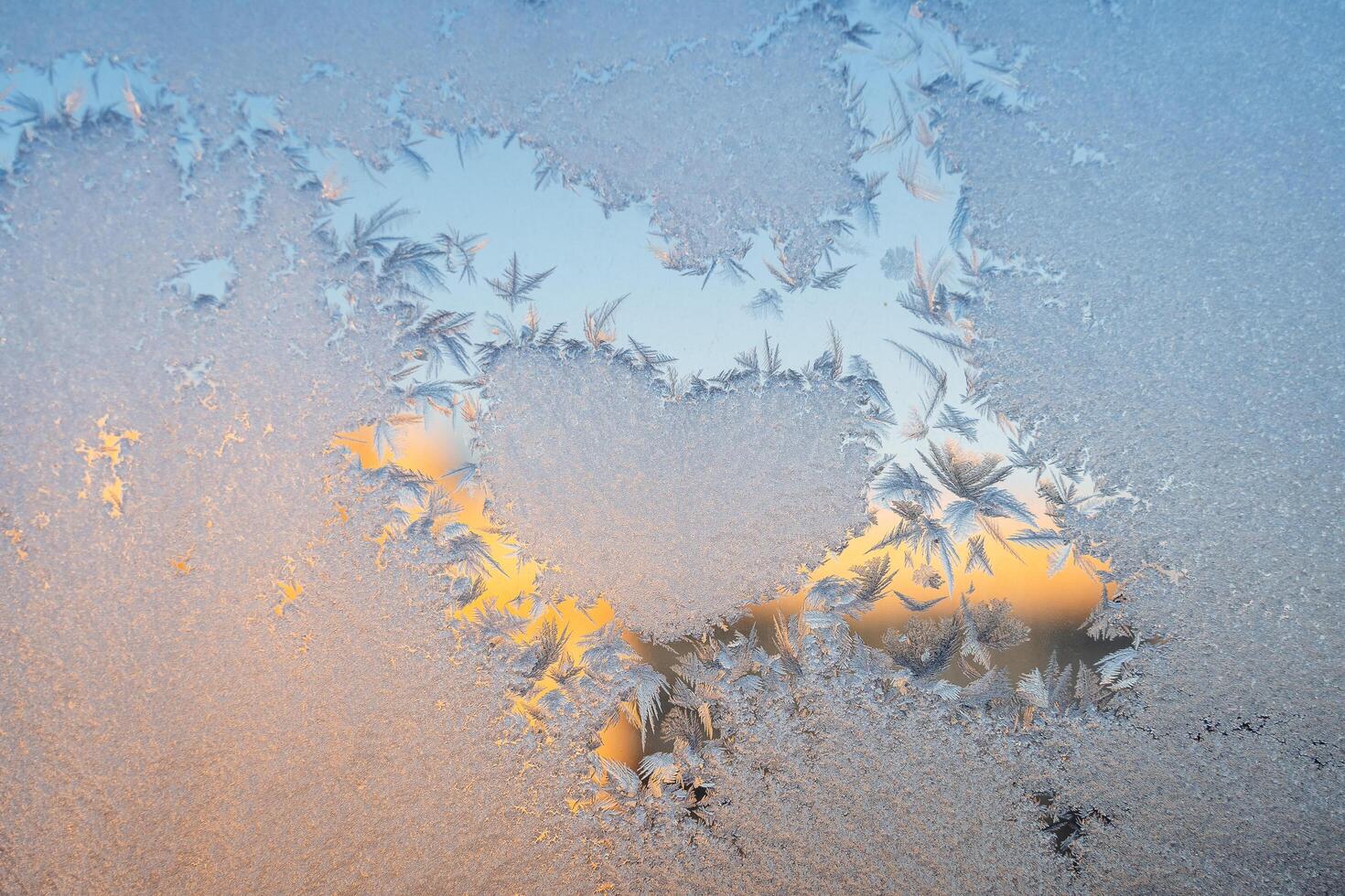 Magical winter patterns on the glass. Natural phenomena. Winter decorations, frozen water on the window. photo