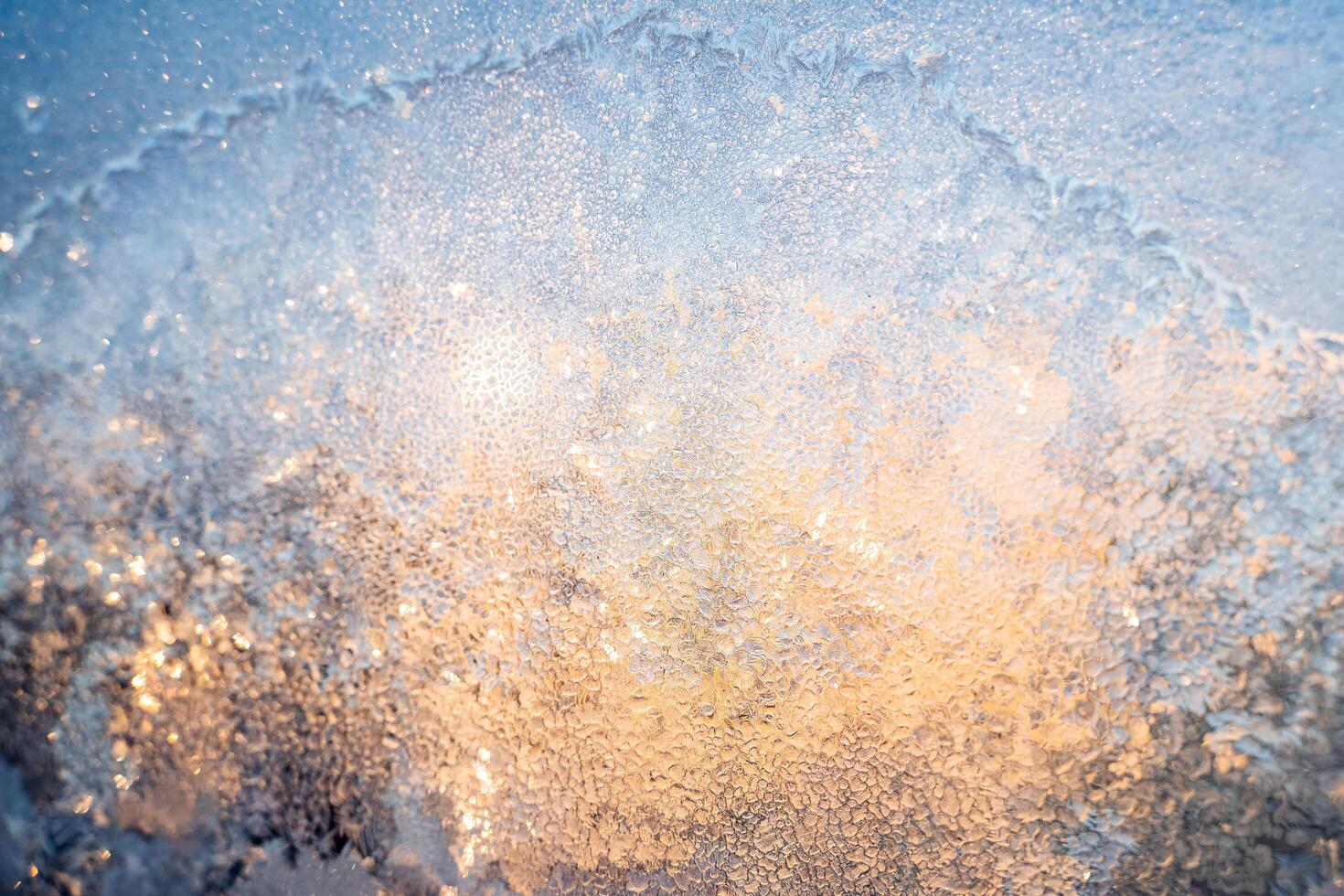 The texture of the glass covered with frost in winter in cold. Magical winter patterns on the glass. Natural phenomena. Frozen water on the window. photo