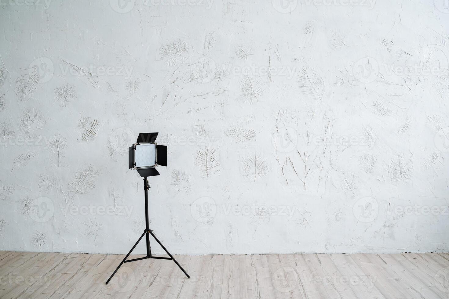 Studio light on the stand stands on a minimalist background. Equipment for photo studio, interior shooting.