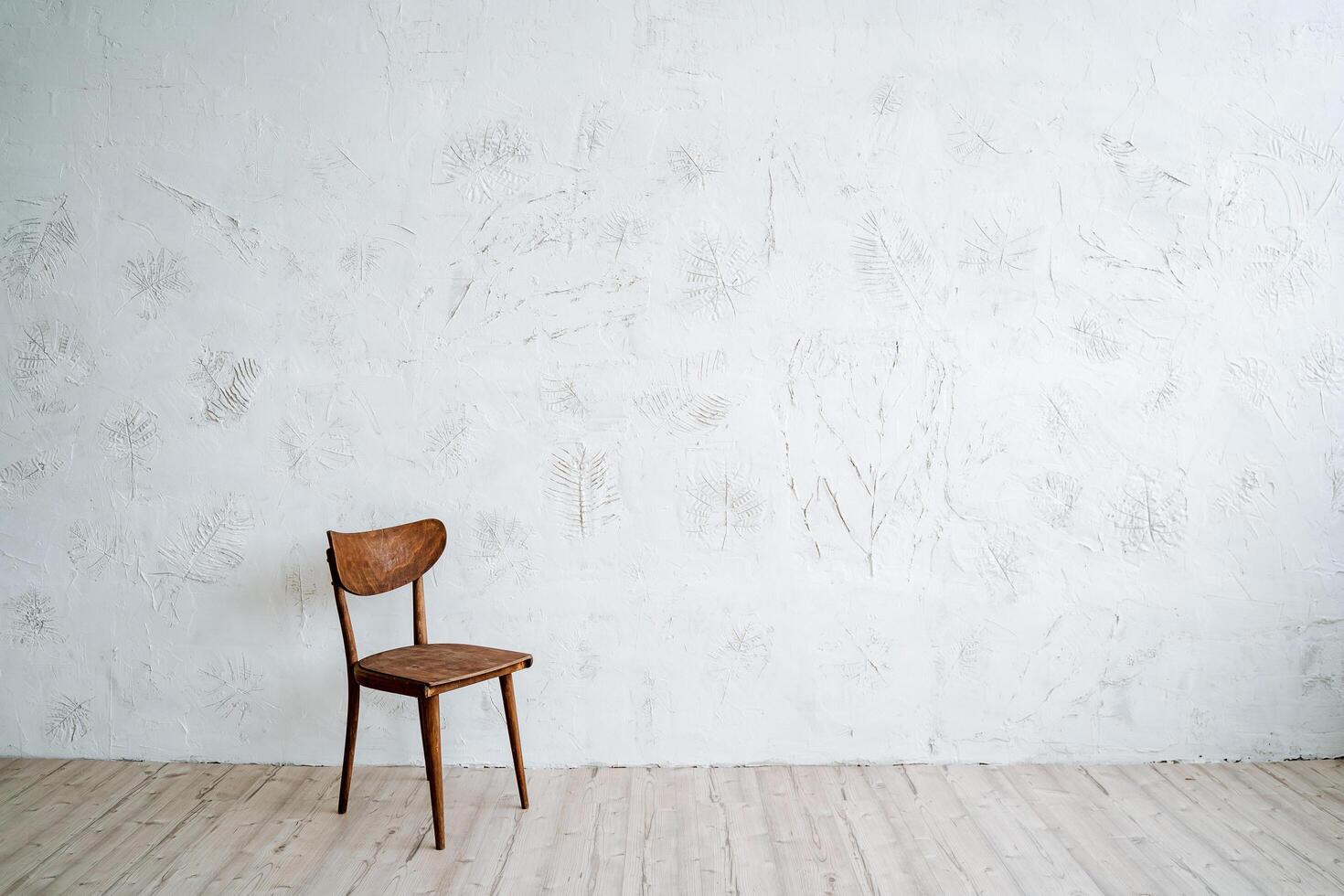 Wooden chair on a minimalist background. A chair in the middle of a bright room. Resting place, comfortable backrest photo
