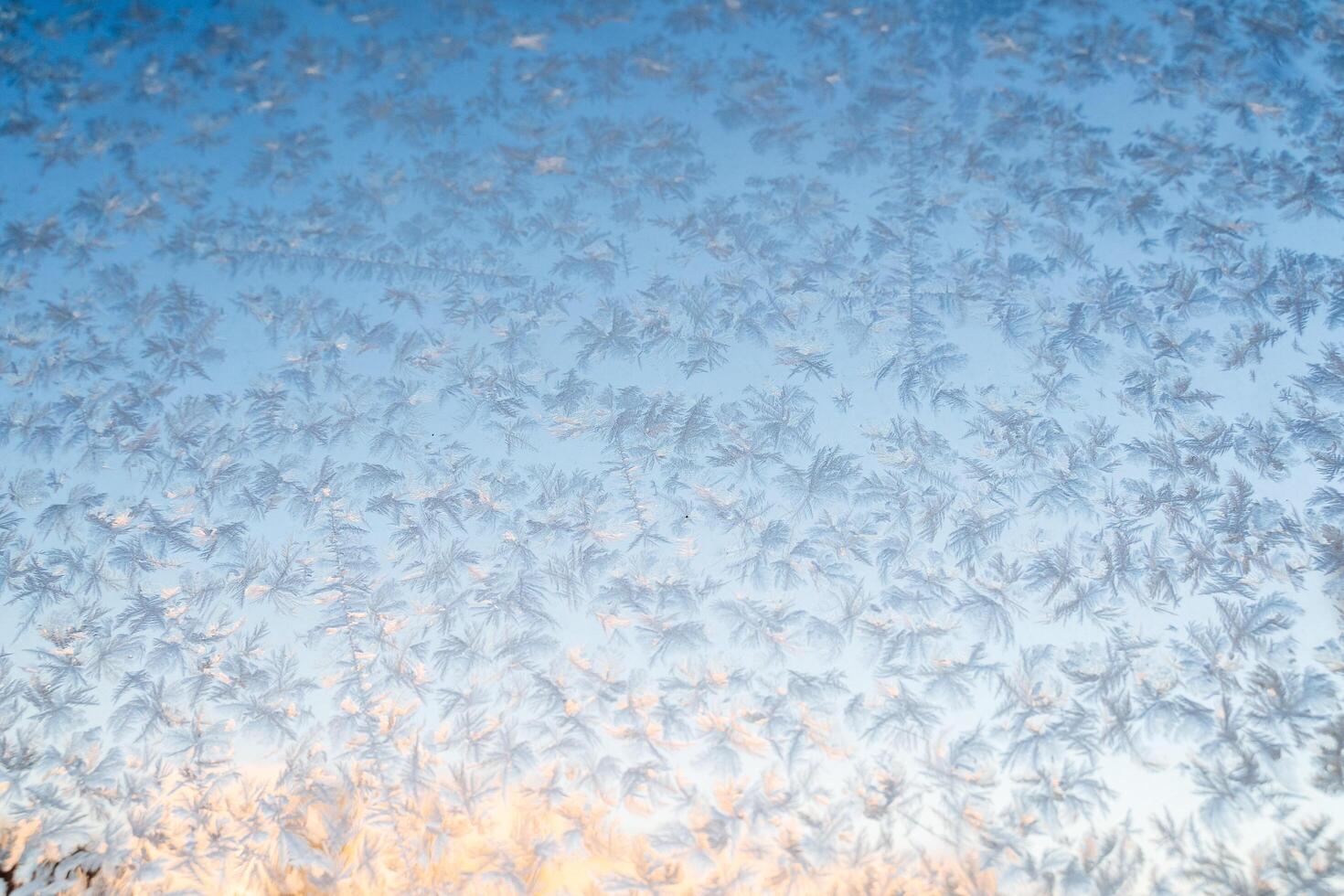 Natural phenomena, Magical frost and ice patterns on a winter glass. Winter decorations, frozen water on the window. photo