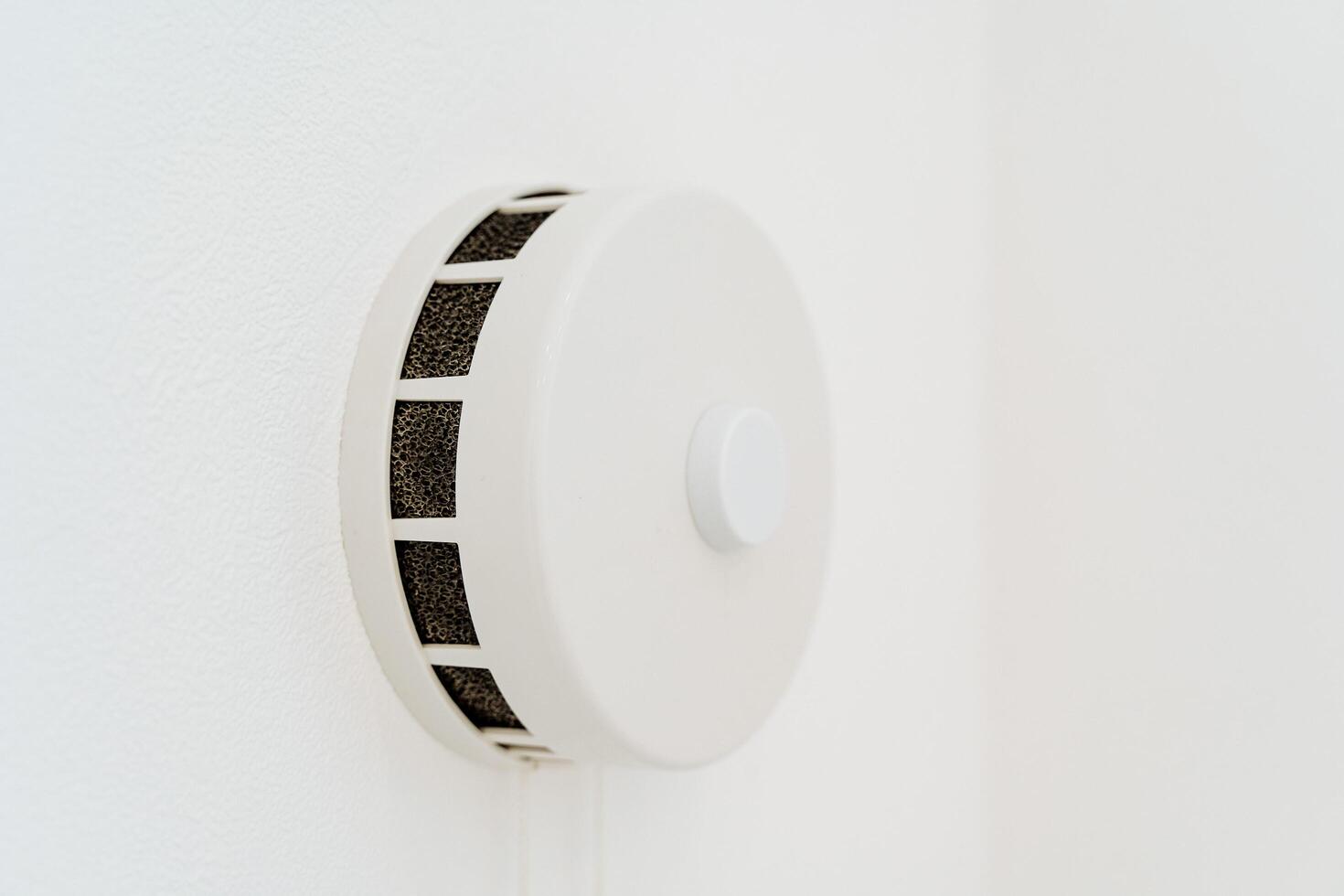 Round ventilation valve on a white wall. Fresh air in the apartment thanks to the ventilation system. Arrangement of a modern home. photo