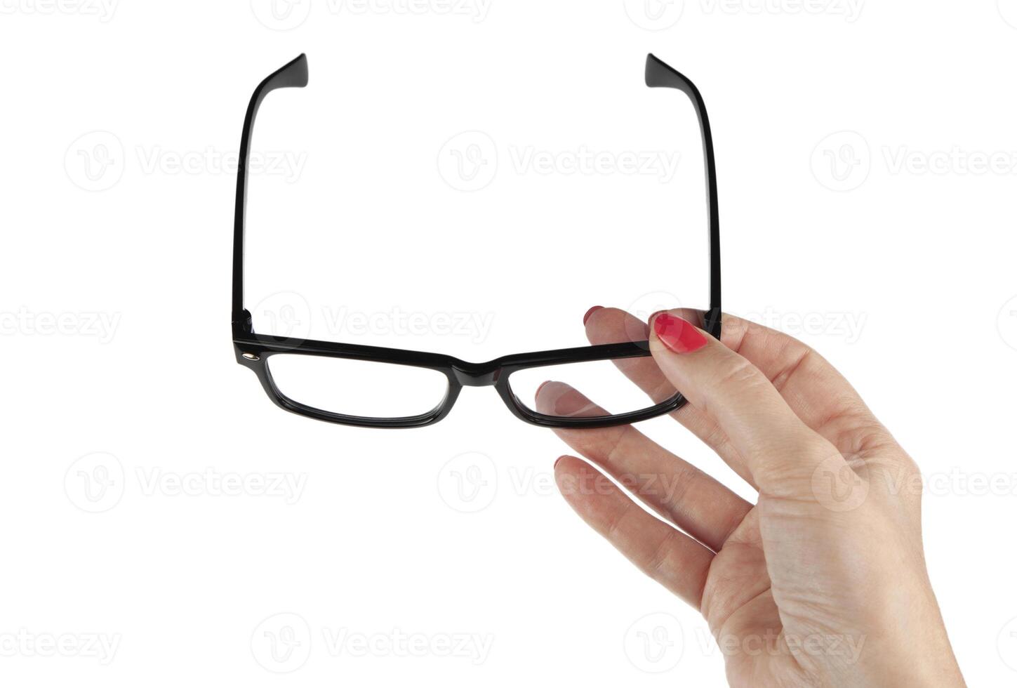 Female hand holding a black-framed glasses isolated on white background photo