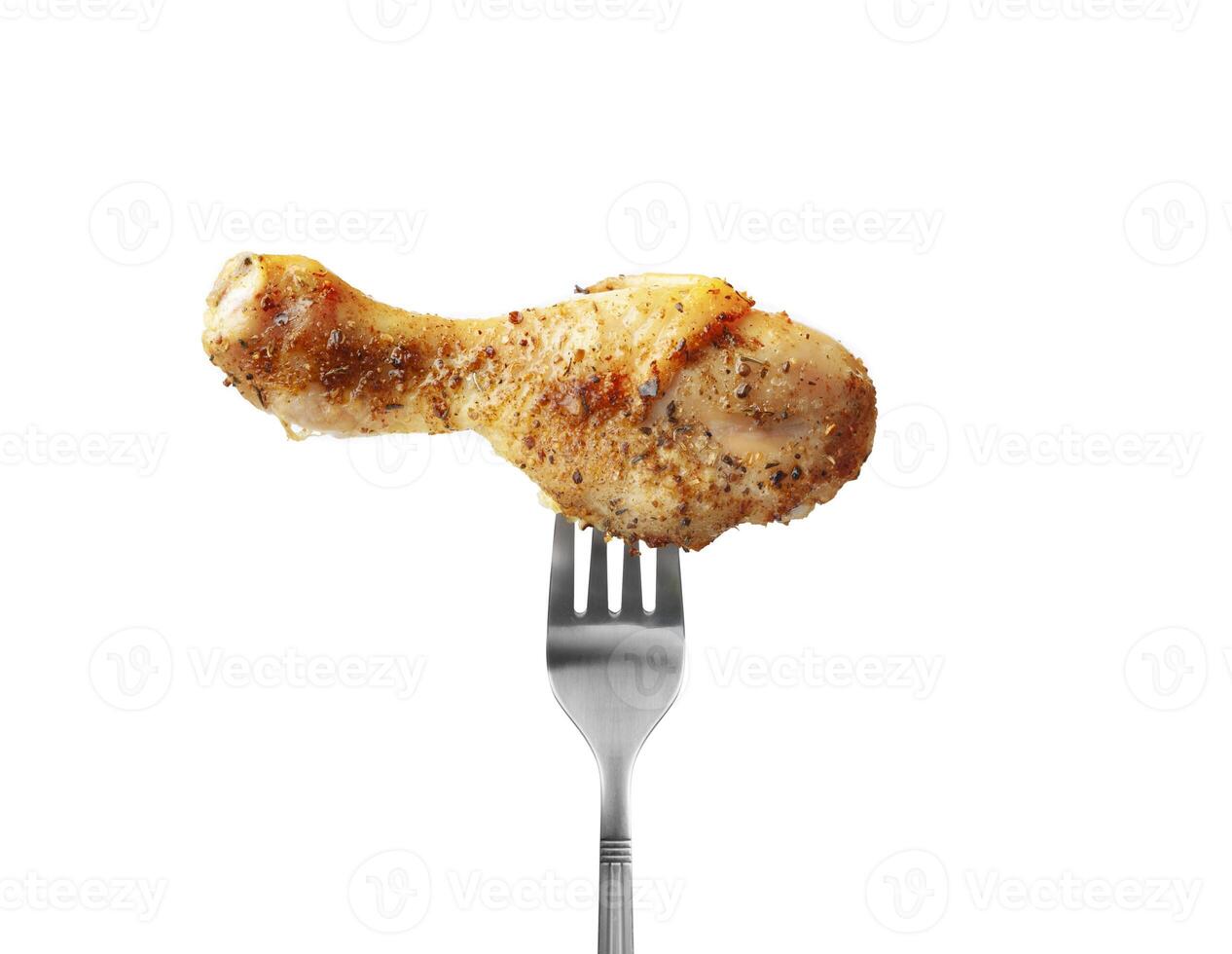 Baked chicken drumstick on a fork isolated on white background photo