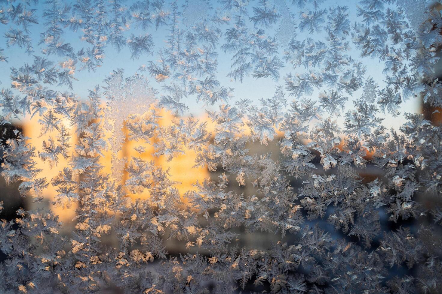 The texture of the glass covered with frost in winter in cold. Magical winter patterns on the glass. Natural phenomena. Frozen water on the window. photo