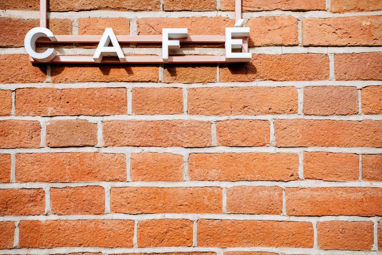 Wooden sign of the caf against the background of a brick wall. Sign at the institution, the name of the cafe photo