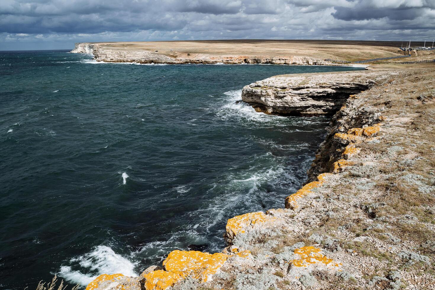 mar capa. vistoso Disparo de el marina. grueso mar espuma y brillante azul agua. rocas cubierto con musgo. obeso cielo gastos generales. otdykh por el mar foto