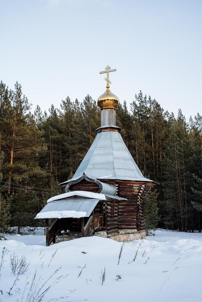 Orthodox church chapel stands in the winter forest. Russia Epiphany frosts. A place for prayer. The old church is lost in the taiga. Quiet location photo