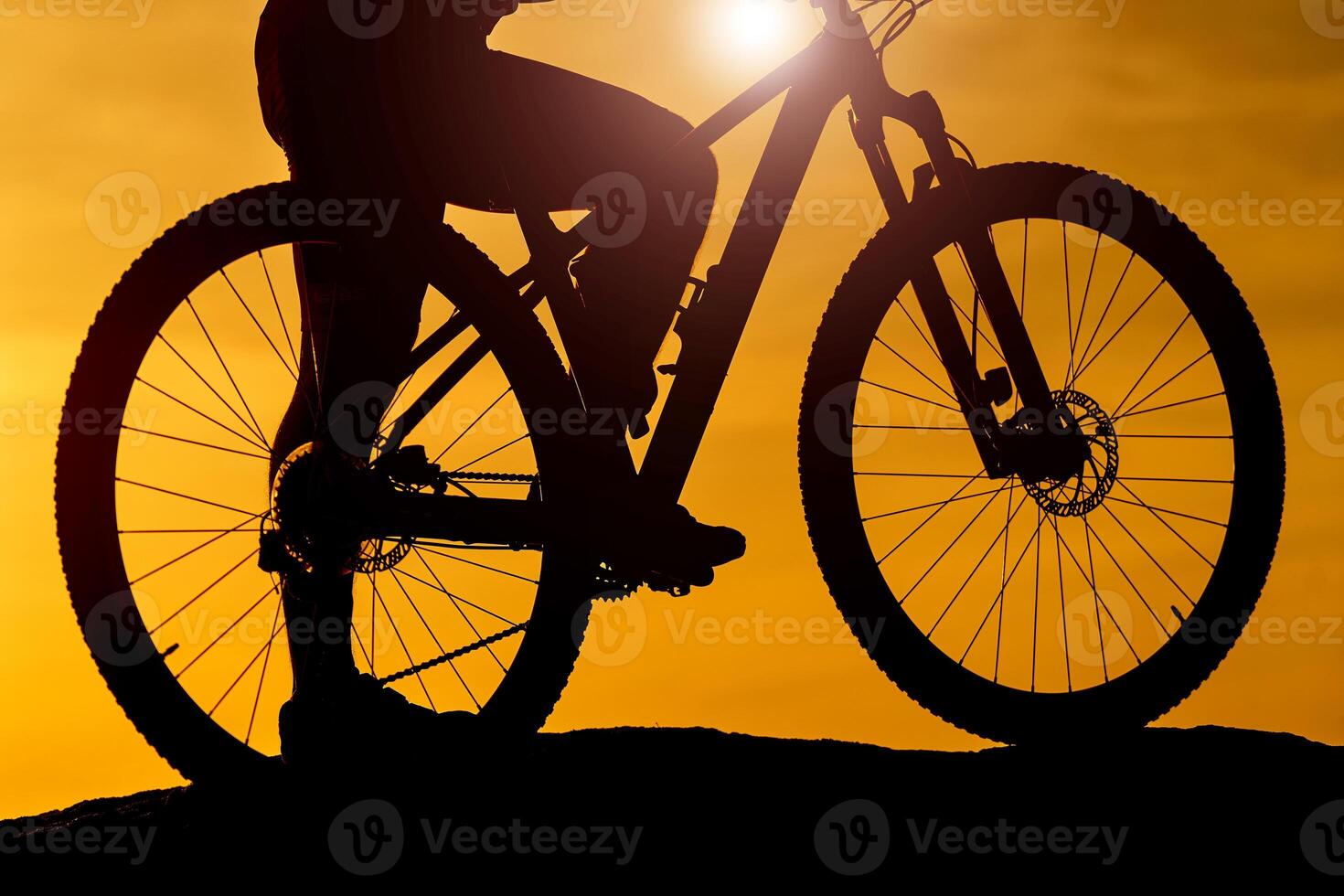 Silhouette of cyclists at bike at sunset. Vehicle closeup. River background. photo