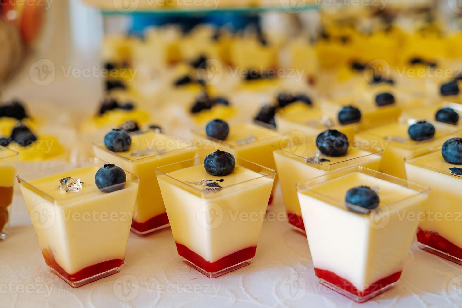 Candy bar. Table with sweets, candies, dessert. Closeup of mini cheesecakes with blueberry on the top. Fruit jam on the bottom. photo