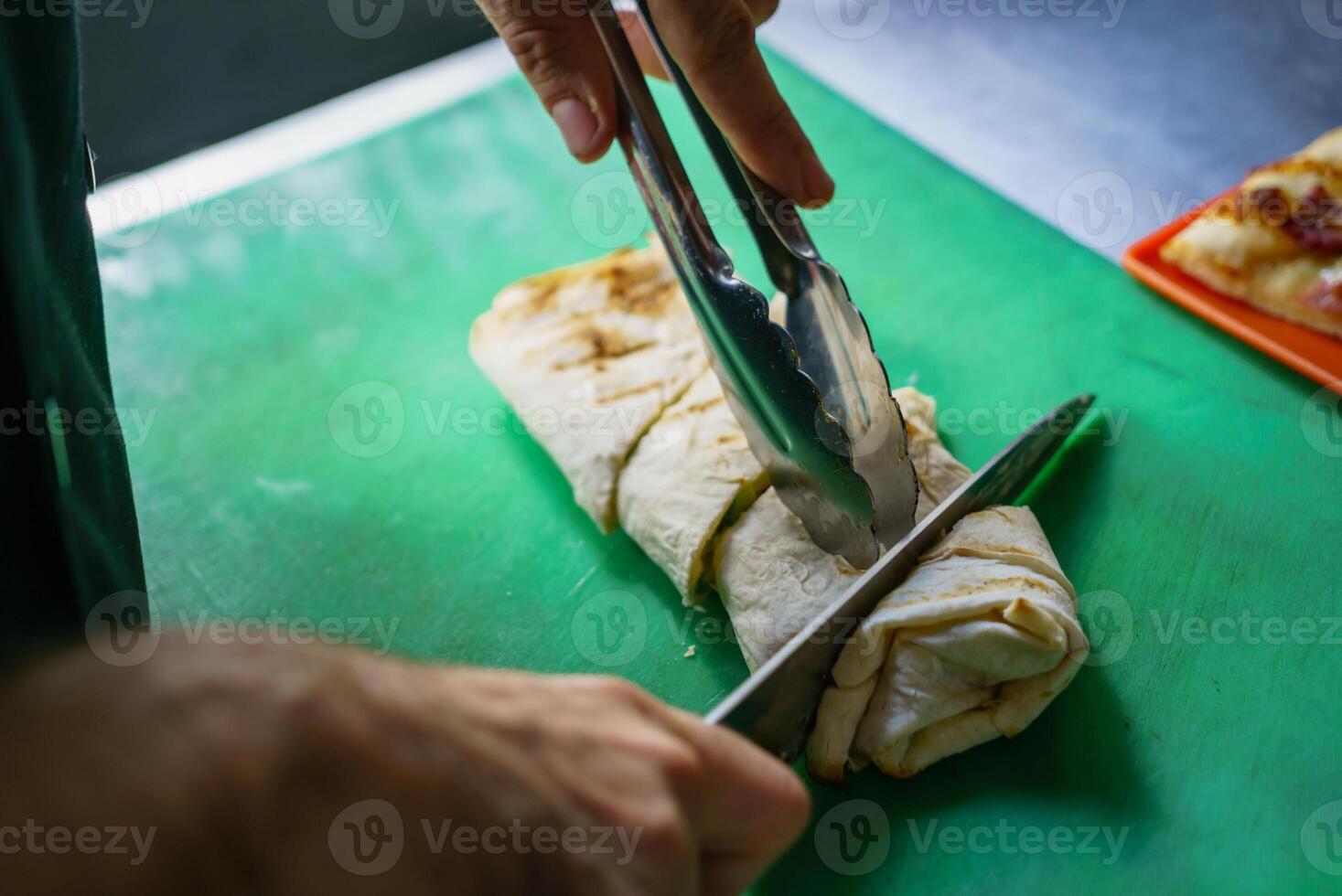 cocinar cortes un tortita rodar con un cuchillo en el tablero para servicio un plato. foto