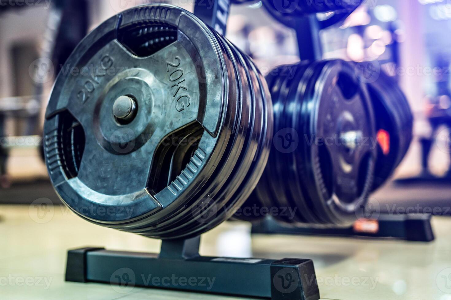 Black barbell metal plates on a background of sports, fitness club. Modern disks for barbell in the gym. Close up. Gym equipment concept. photo