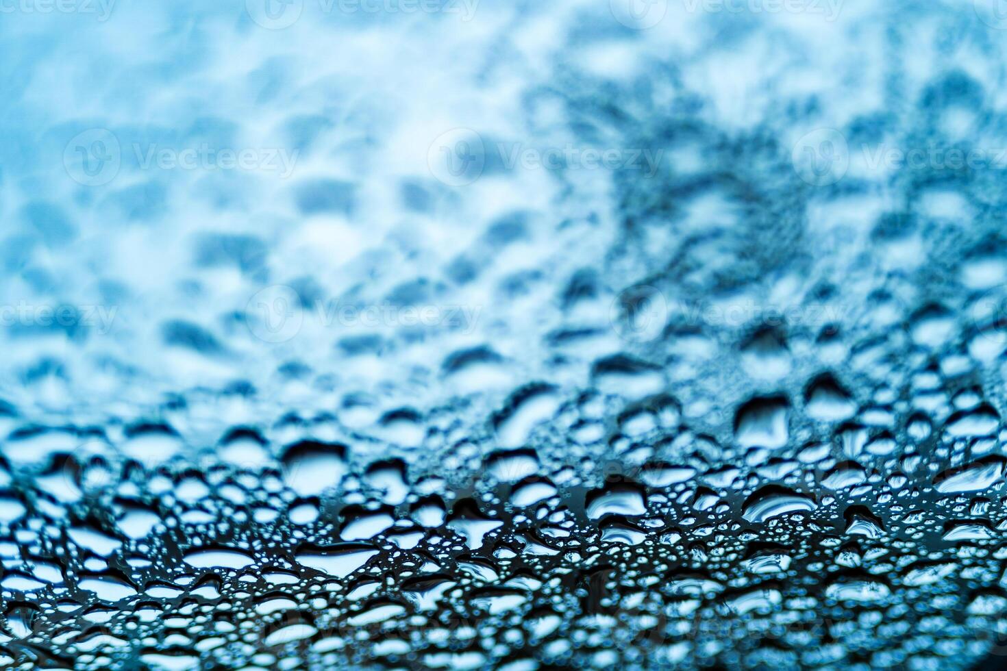 brillante claro burbujas de agua gotas en el ventana después el lluvia en azul antecedentes. gotas de lluvia en el vidrio.macro Disparo foto