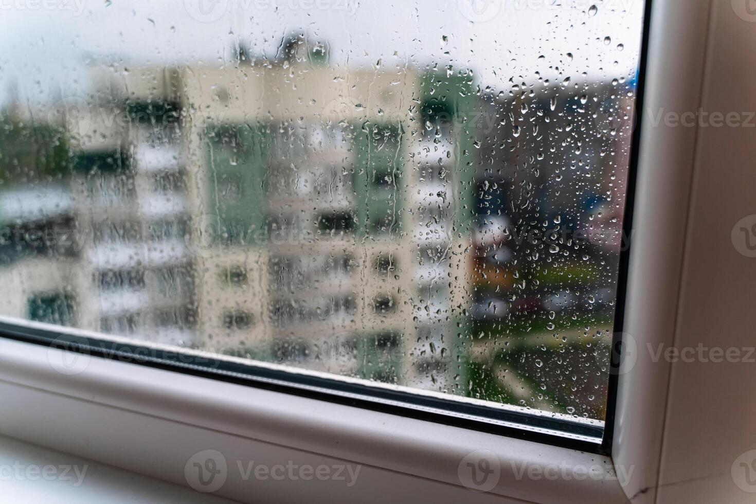 Raindrops on window glass. Selective focus. Rainy city background photo