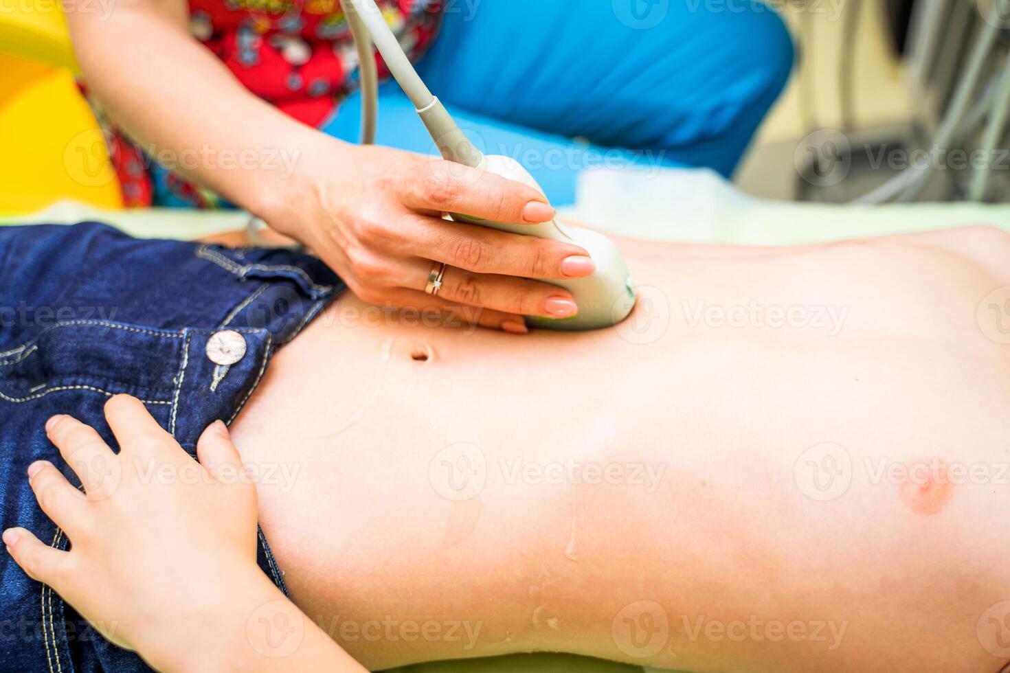 Boy under ultrasonic examining at hospital. Closeup of belly sonogram. photo