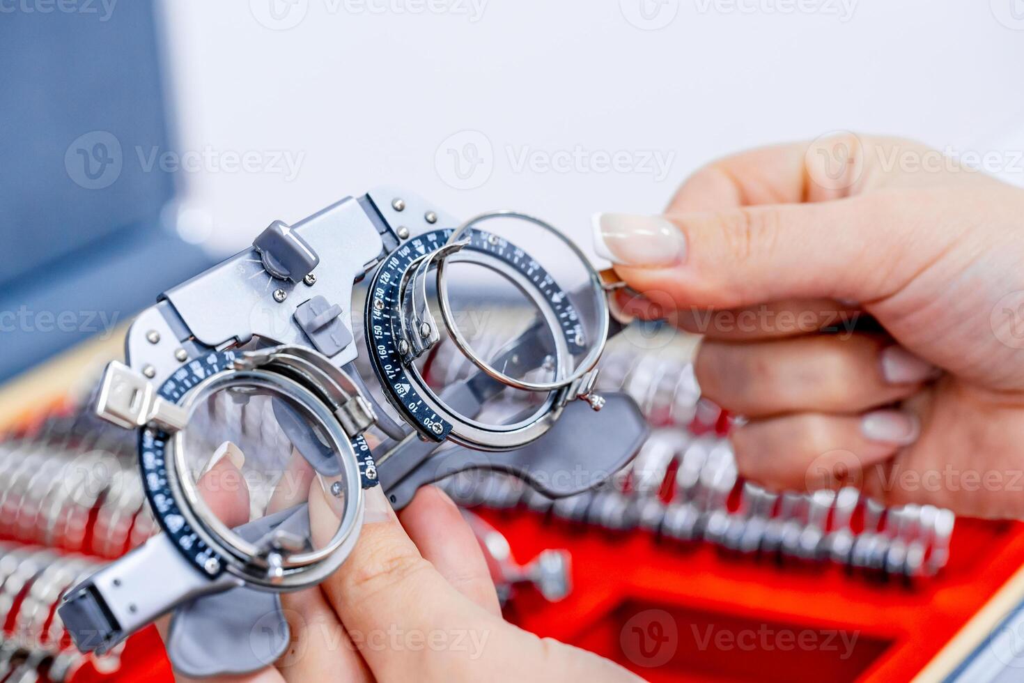 Close-up of ophthalmological trial frame and test glasses in woman's hands. Eysight correction. Young girl is holding corrective spectacles. photo