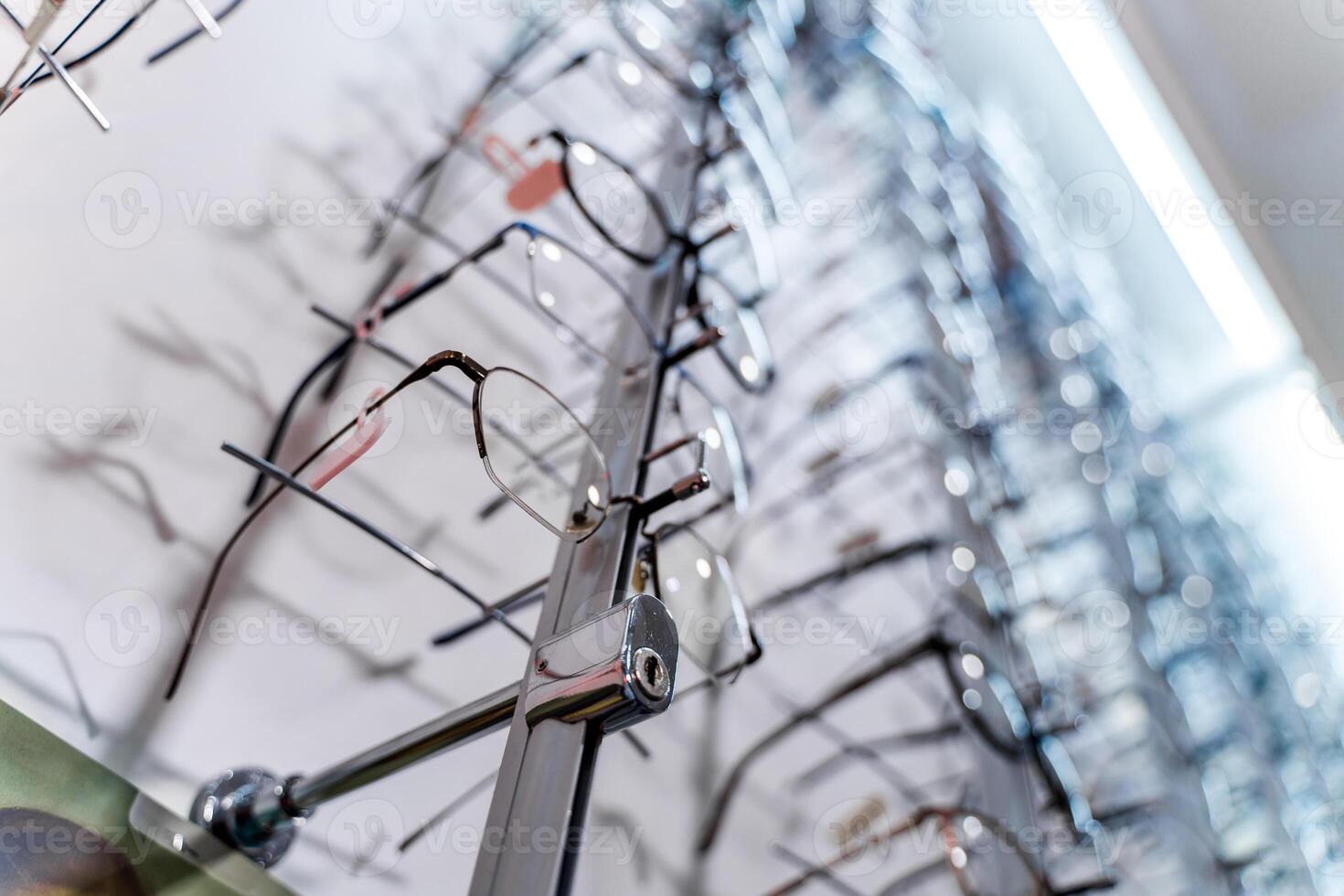 A rack of eyeglasses in shop. Showcase with spectacles in modern ophthalmic store. photo