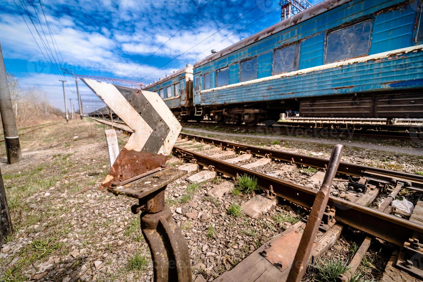 old rusty weathered peeled paint of an old wagon. Blue abandoned railway carriage. Old railwaystation. photo