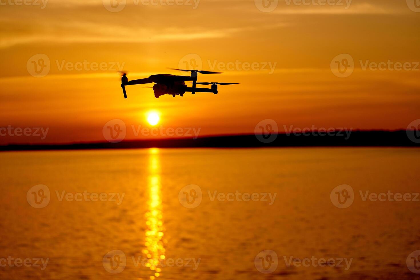 drone quadcopter with digital camera flying at sunset. Beautiful sunset on the river photo
