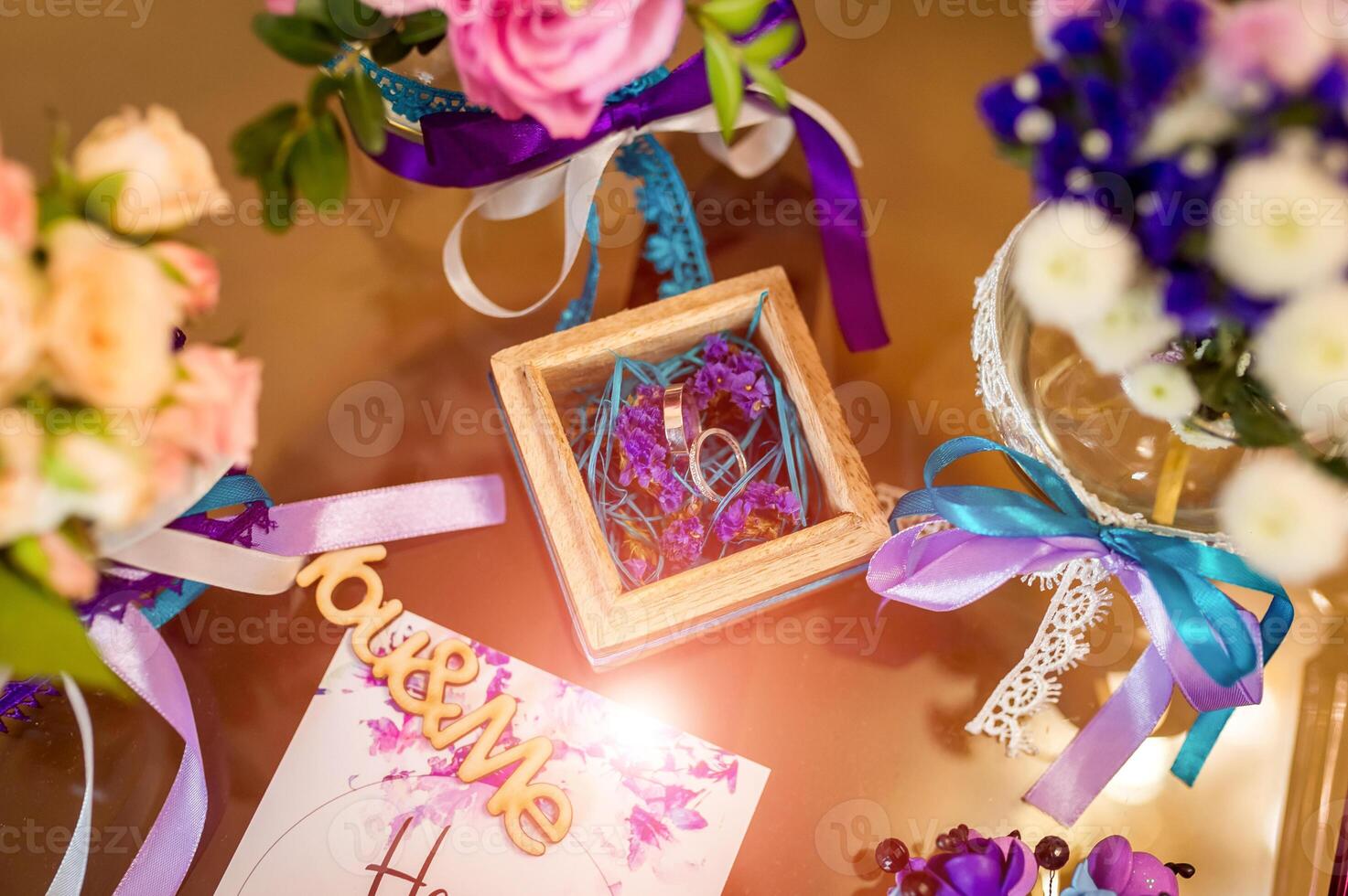 Wedding Decoration. Golden rings in wooden box with colorful ribbons inside. photo