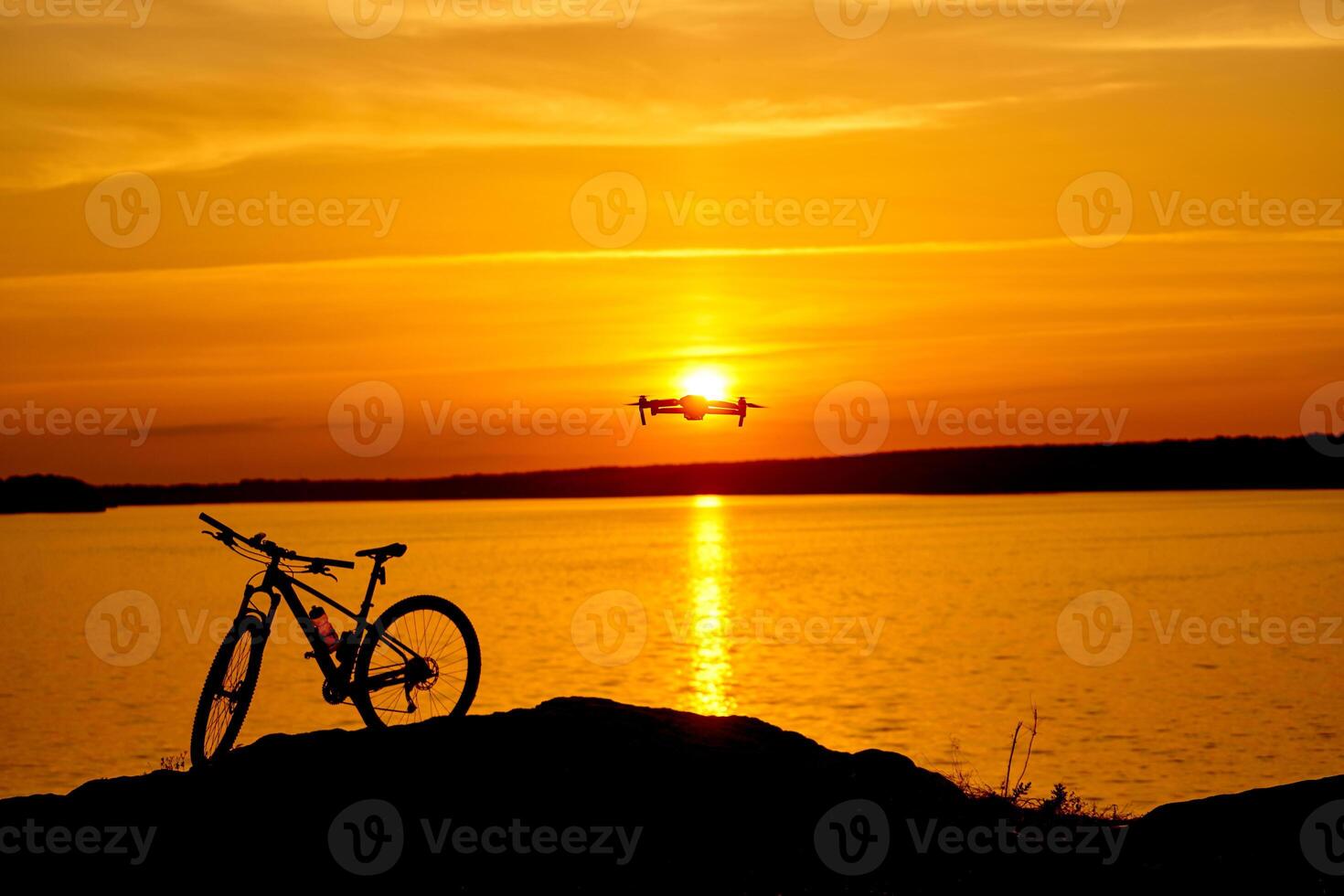 silhouette of a bicycle at sunset. drone quadcopter with digital camera flying at sunset photo