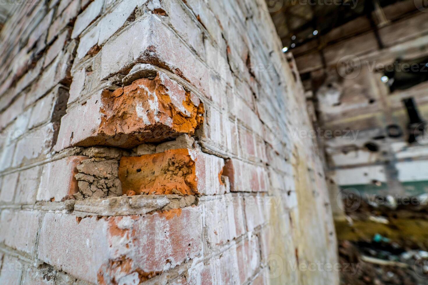 Close-up of old bricks wall in the abandoned place. Ruined and collapsed abandoned building with broken red bricks photo