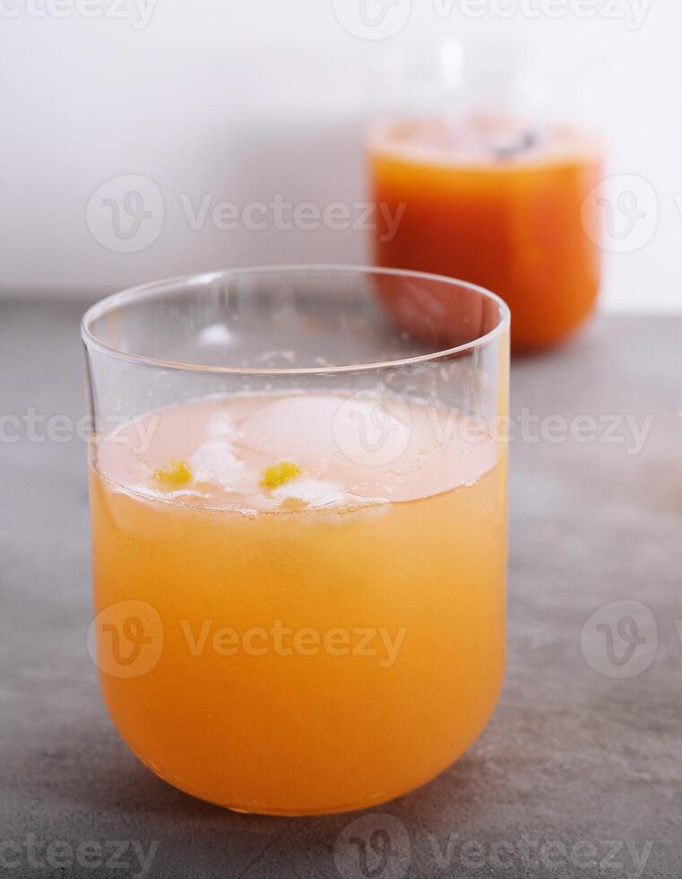 pineapple and carrot juices in glass with cubes Ice photo