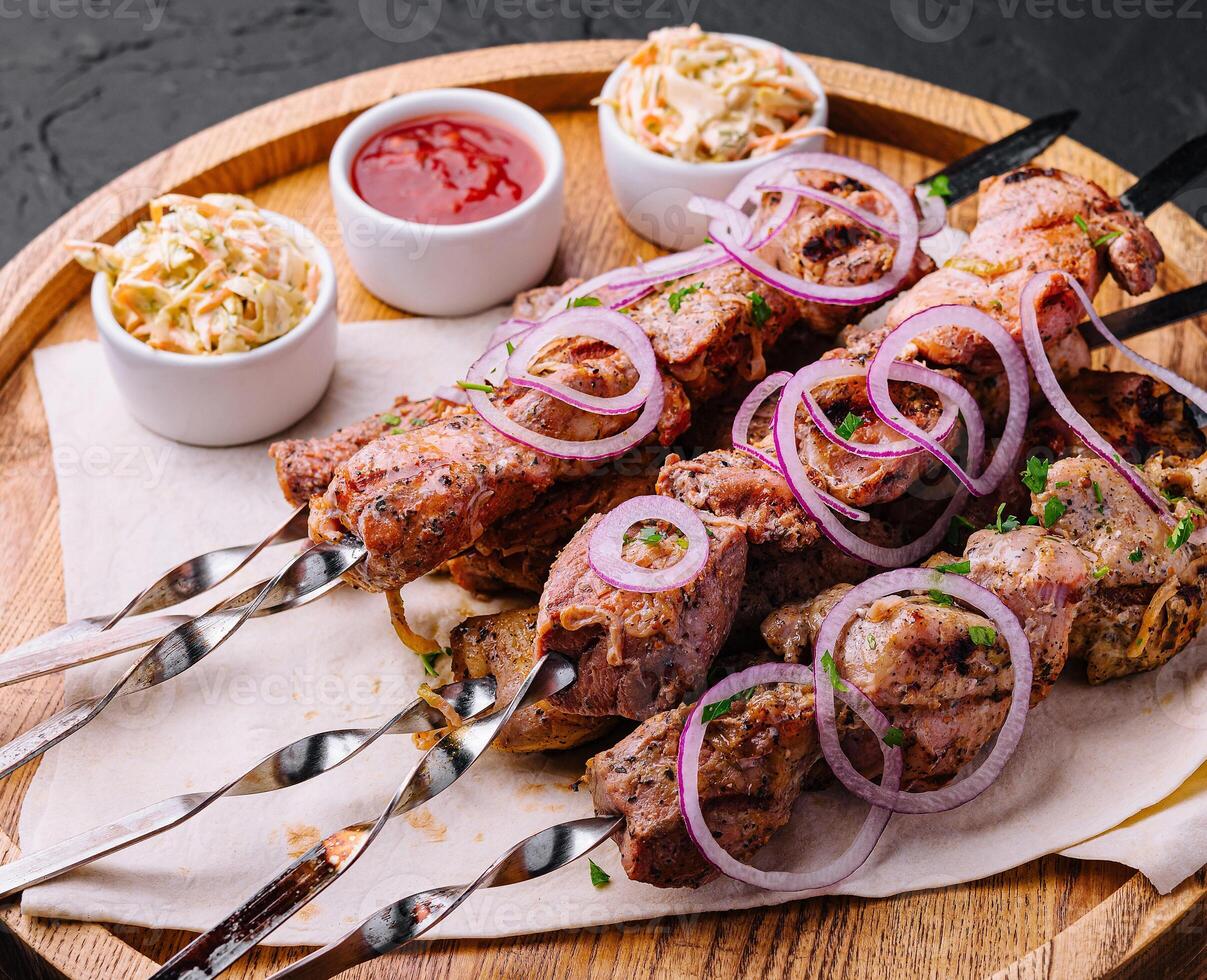 kebabs from pork on skewers on wooden board photo