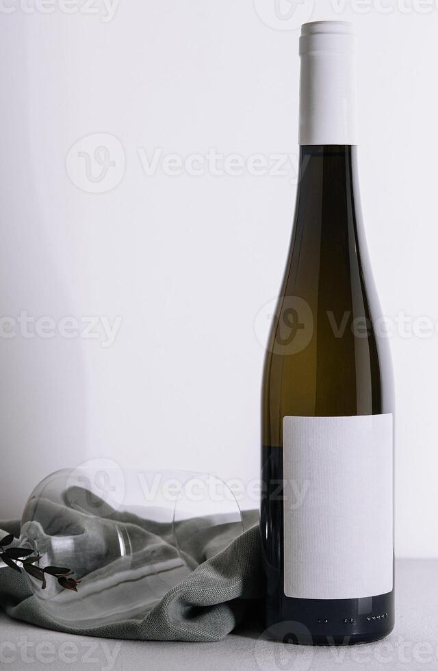 White wine bottle and glass on white photo