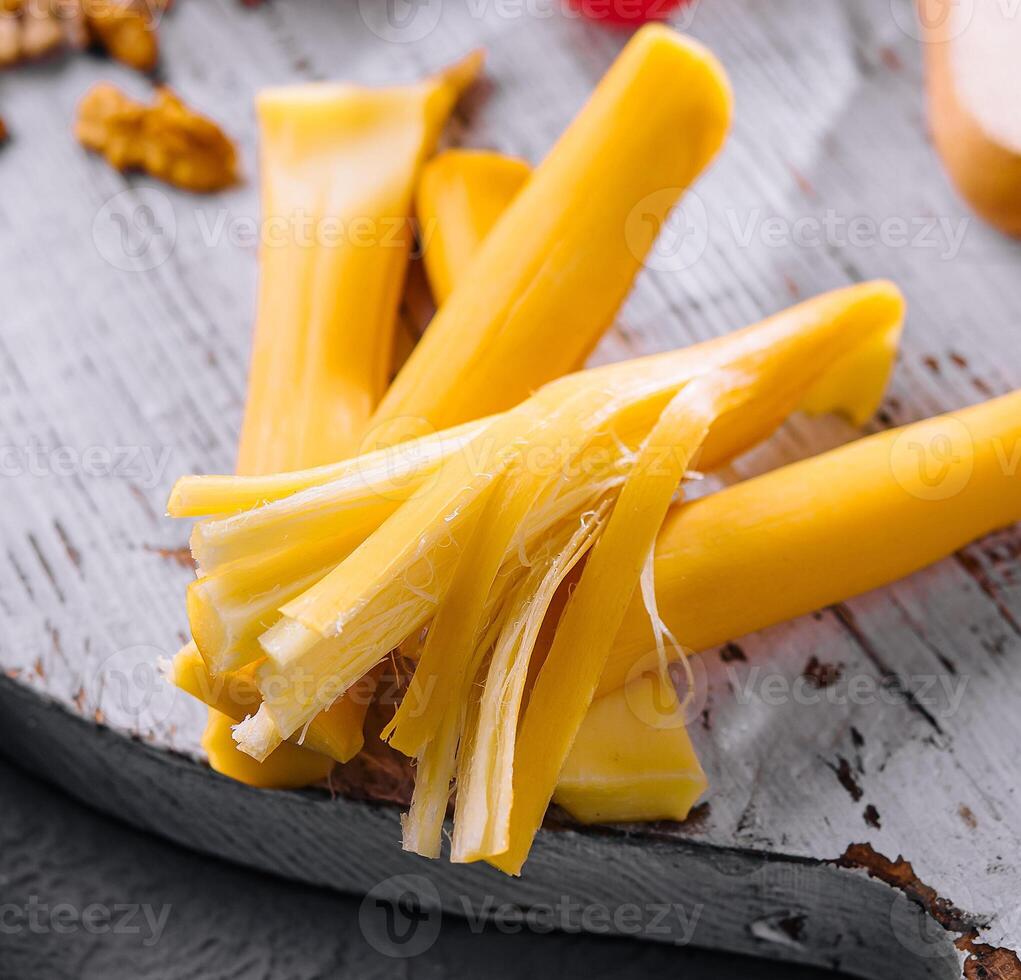 Smoked braided cheese on wooden board photo
