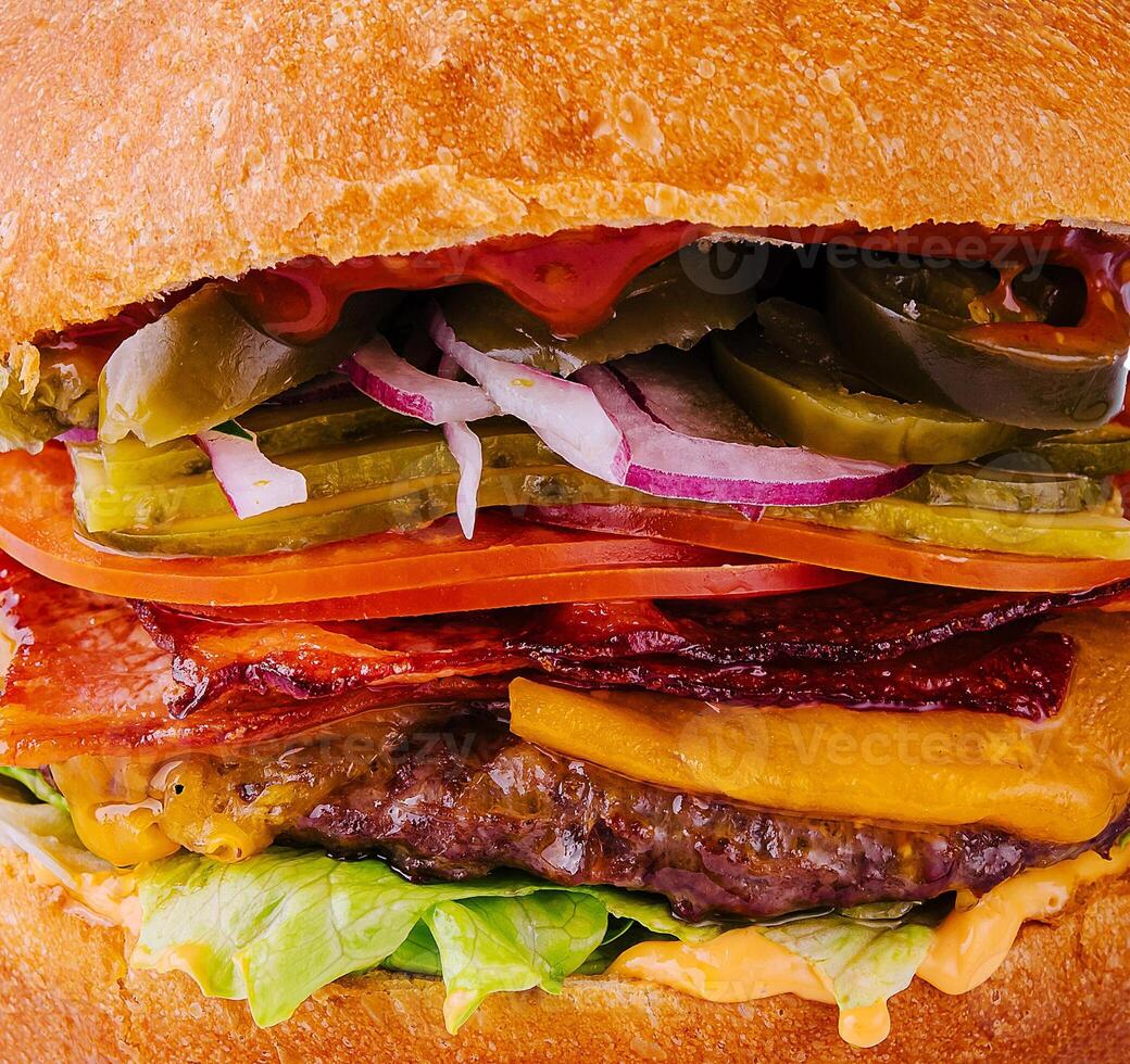 hamburguesa con carne de res, tomate, queso, tocino y lechuga macro foto