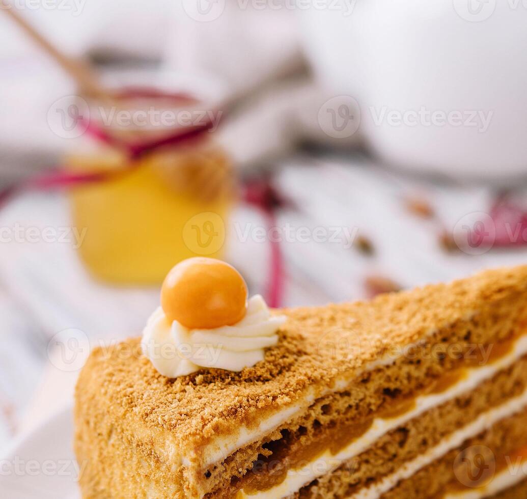 Layered orange cheesecake on plate on wooden table photo