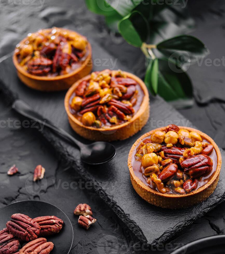 tartaletas con caramelizado nueces en negro mesa foto