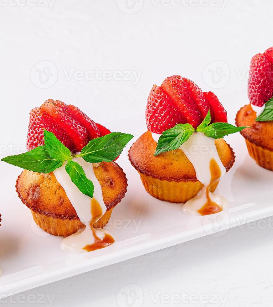 Vanilla cupcakes with strawberry on white plate photo