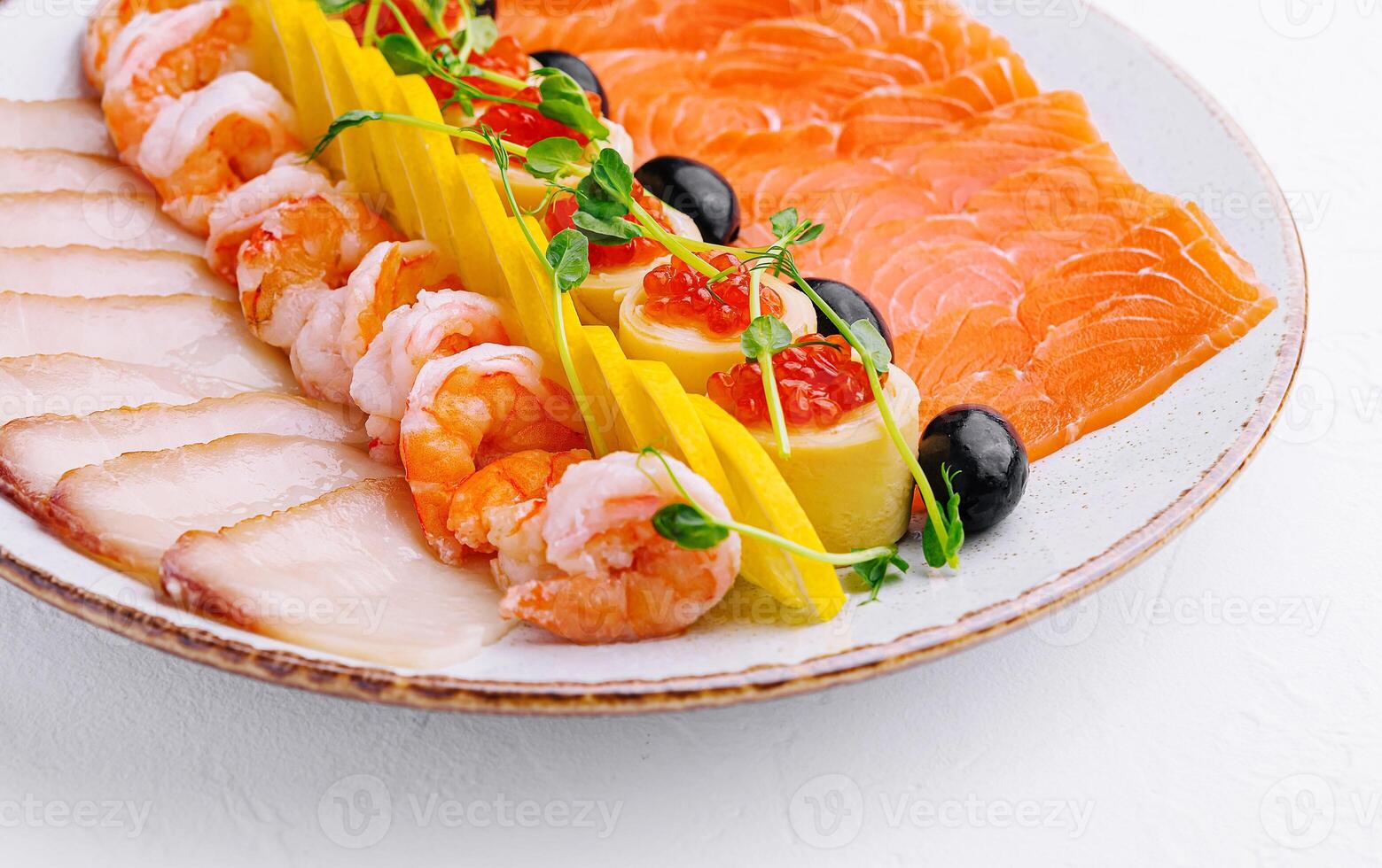 salmon, white fish, shrimp and red caviar on plate photo