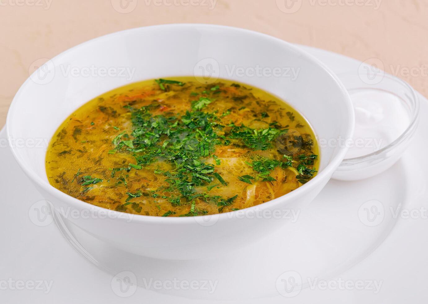 parsley noodle soup on white bowl photo