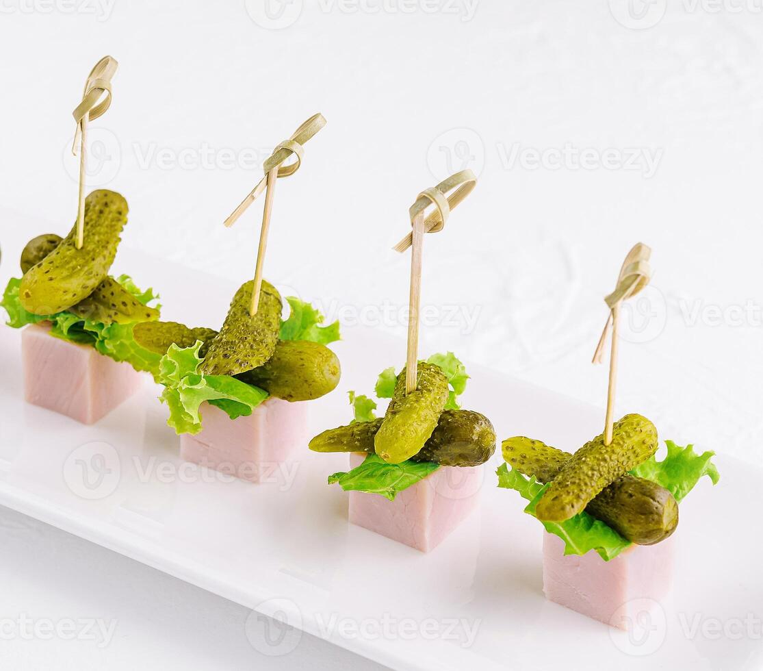 pieces of ham with small pickled cucumbers photo
