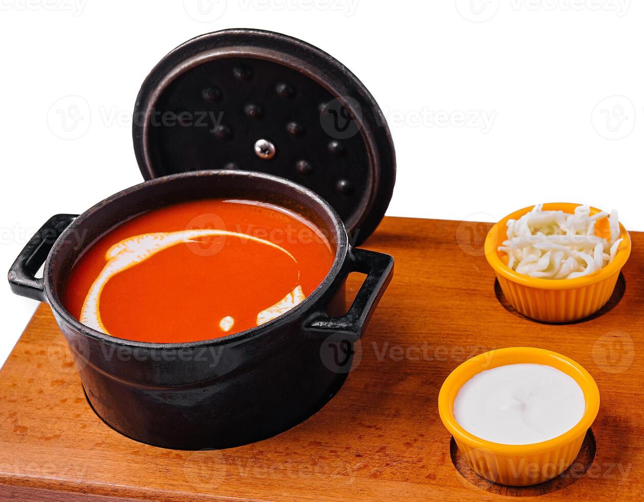 Tomato soup gazpacho in stewpan and suluguni cheese photo