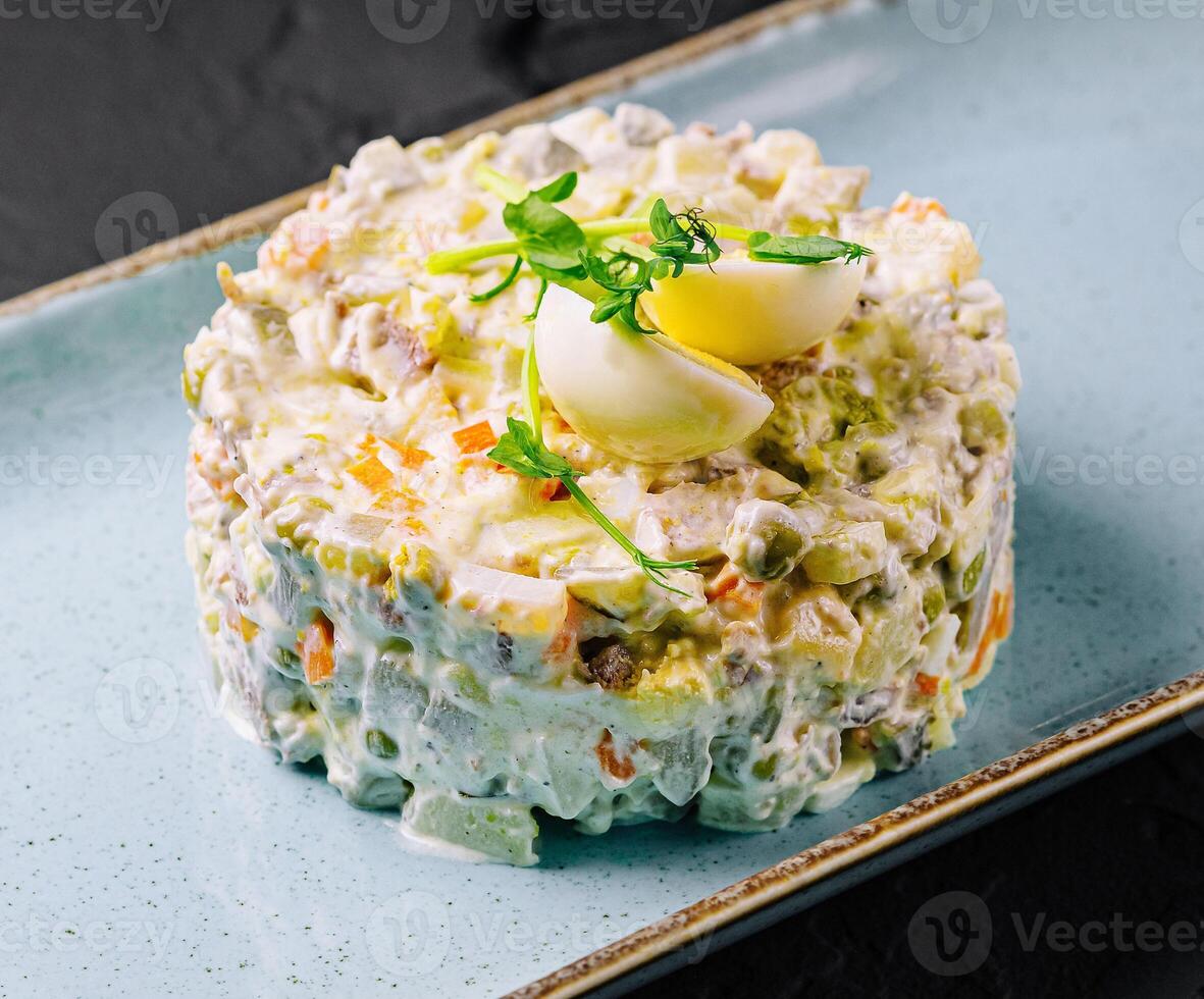 Salad Olivier on blue plate photo