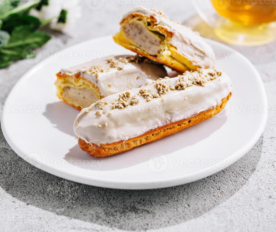 eclairs with white glaze and poppy seeds and tea photo
