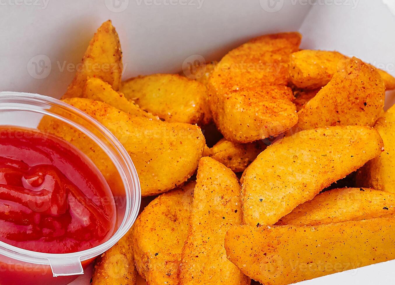 Fried potato wedges in takeaway box photo