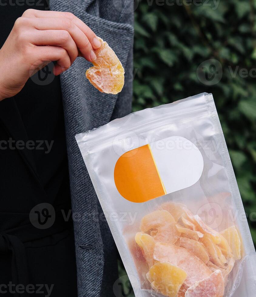 Girl Eating Dried Mango Slices photo